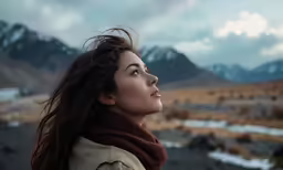 a woman is looking up at the sky while wearing a scarf