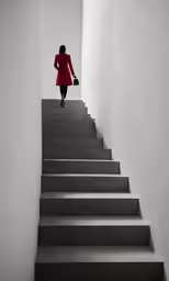a woman walks down a stairwell on some concrete stairs