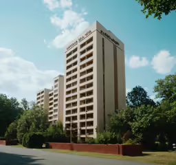 an apartment building with large windows and a lot of landscaping on the ground