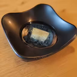 a piece of bread is sitting in a black dish