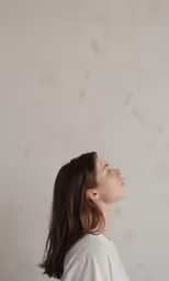 a woman looking up while standing on a white surface
