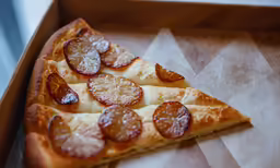sliced pepperoni pizza in a brown tray