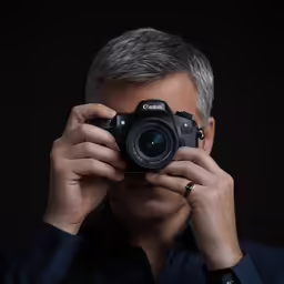 a man taking a photo of himself holding a camera