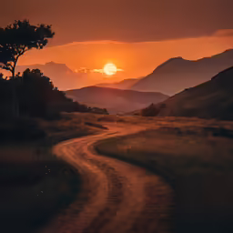 the sun is setting in the mountains as the road goes through