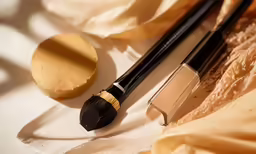 a foundation powder and mascara on a table