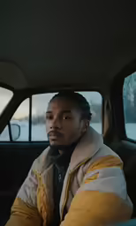 the man is sitting in the car and looking into the distance
