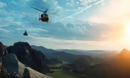 an image of two people hanging on to a helicopter above mountains