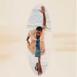a man in white shirt on water with his hand raised up