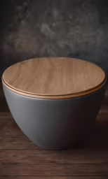 a wooden bowl sitting on a table in front of a wall