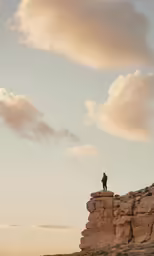 a man standing on top of a rock cliff