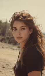 a girl in black shirt standing on the beach