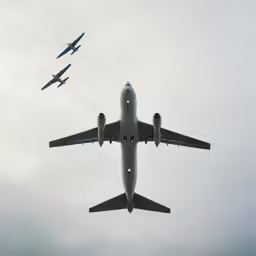 airplanes flying against the sky, with one taking off