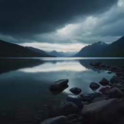 a body of water surrounded by rocks under a cloudy sky