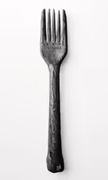 a large fork on the side of a white wall