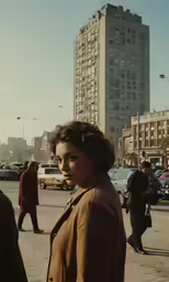 a young woman stands alone in a city intersection