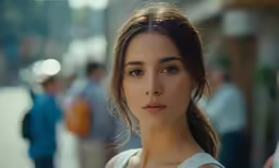 a woman looking directly at the camera in an alley