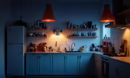 a kitchen area that includes a white refrigerator and light blue cabinetry