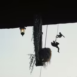 people performing aerial acrobatic stunts on their sails