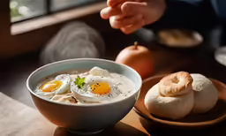 a wooden table topped with two bowls of food