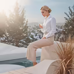 a woman sitting next to an icy pool