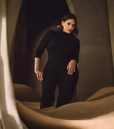 a woman wearing a black outfit poses for a picture