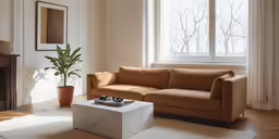 an all white living room with a tan sofa