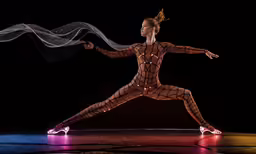 a woman in a costume dancing with long hair