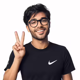 a young man in glasses smiling and making the peace sign
