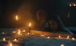people are sitting in the dark near candles