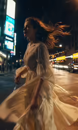 a woman is walking on the street at night