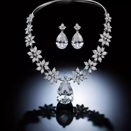 a crystal necklace and earrings are seen on a dark surface