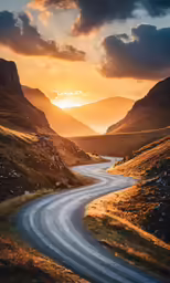 a sunset over a mountain road in the mountains