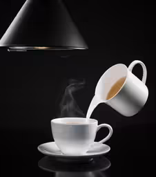 coffee is being poured into a white cup
