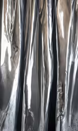 sheer, shiny metal fabric is hanging on a wall
