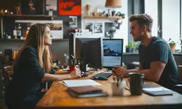 a man and woman talking at the desk