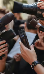 there is a camera person and several people with cameras