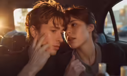 a woman puts her face next to a man in the backseat