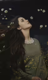 a beautiful woman with long dark hair standing in yellow flowers