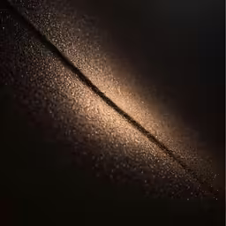 a black surface with tiny beads and a light reflecting on it
