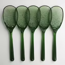 four green oval shaped spoons and one green handle