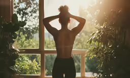 a young man with his back to the camera is facing off into the forest