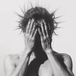 a man is covering his face and hands with his hair