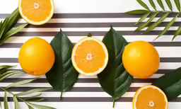 an arrangement of oranges cut up and displayed on a striped table cloth