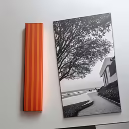 a couple of pictures and an orange marker on a table