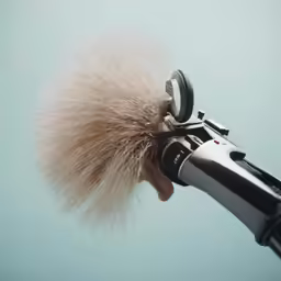 a person with a hair dryer near a camera