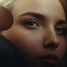 a girl looking into the distance as she is combing her hair