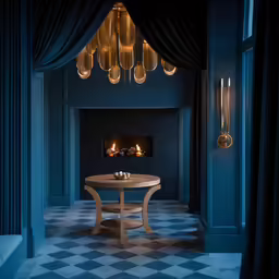 a room with a table and candles near the fireplace