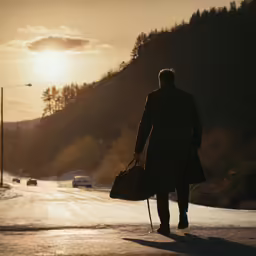 the silhouette of a person walking down the street at sunset