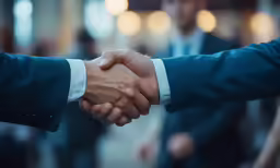 two men shaking hands in front of an audience