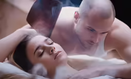 a man and a woman laying in bed with steam coming from the eyes